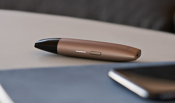 Un appareil de vapotage VEEV de couleur or sur une surface beige