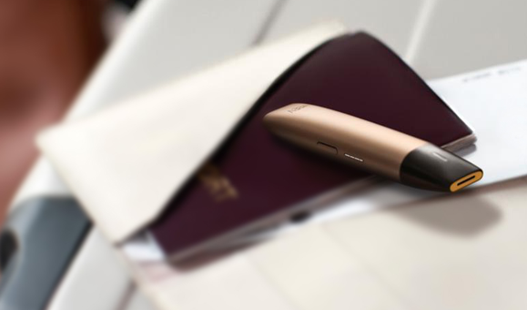 Un appareil de vapotage VEEV de couleur or sur un livre