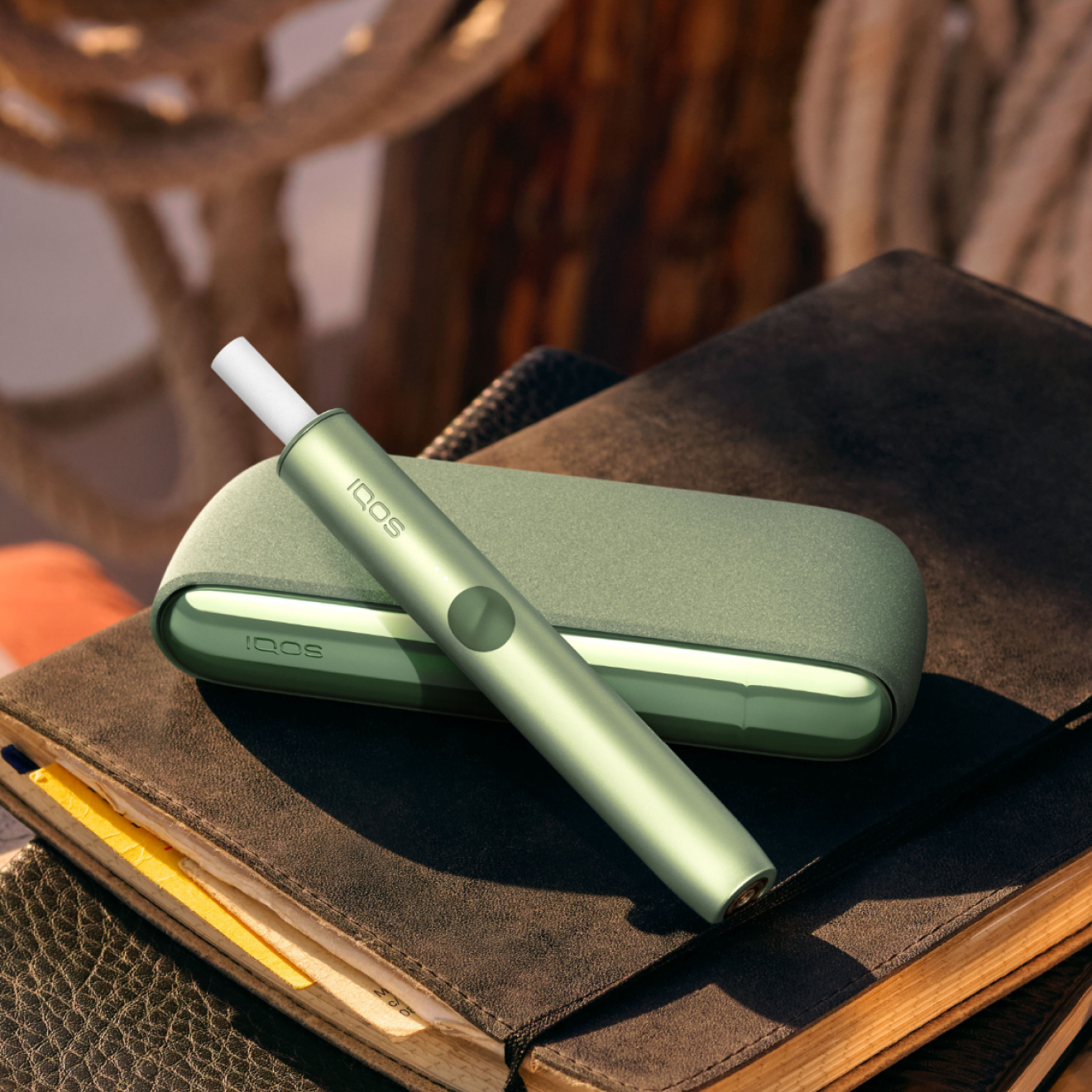Un appareil IQOS ILUMA avec un bâtonnet TEREA à l'intérieur sur un ordinateur portable.