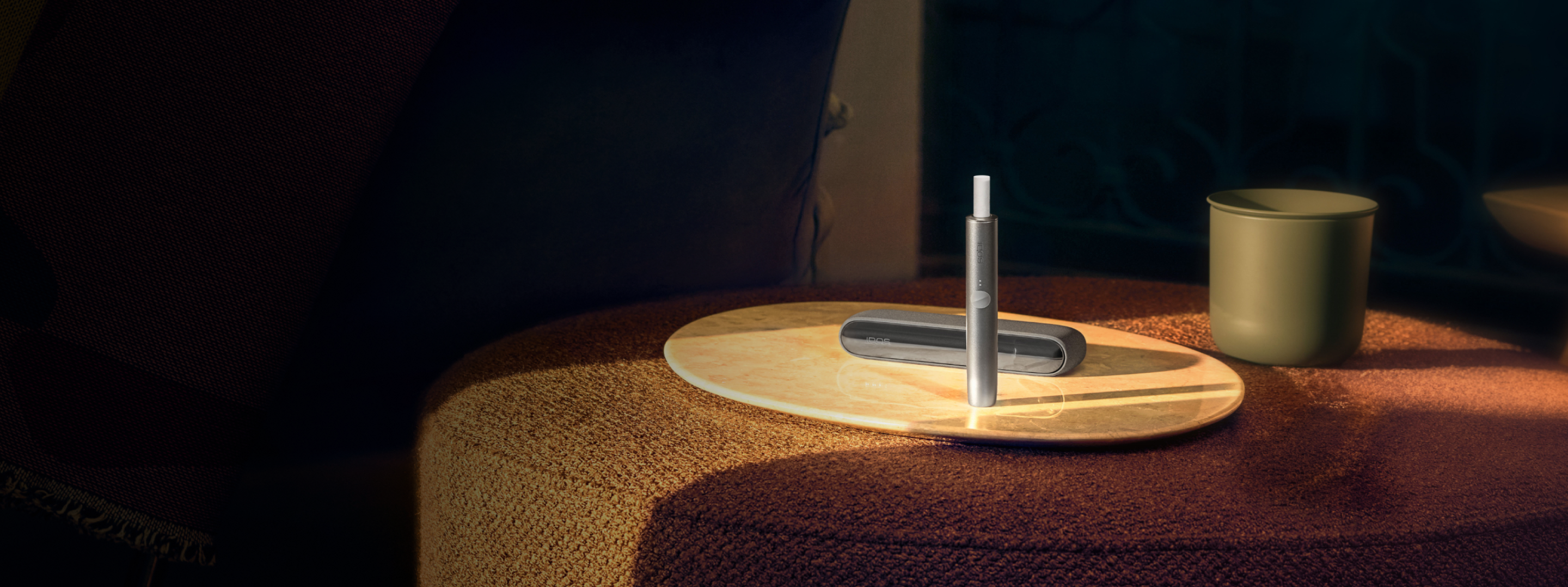 Un chargeur de poche et un support IQOS ILUMA vert mousse.