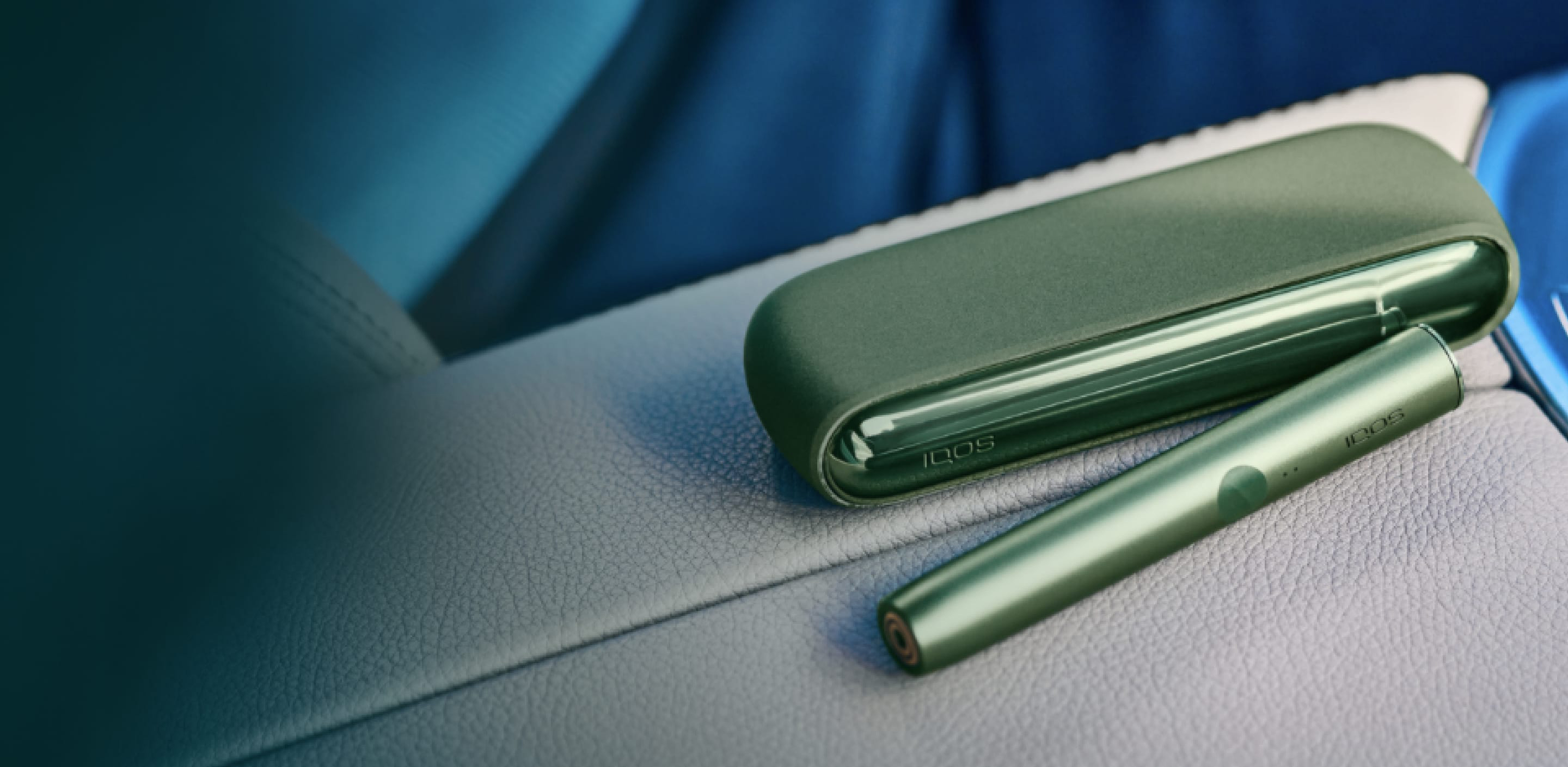 A moss green IQOS ILUMA Holder and Pocket Charger.