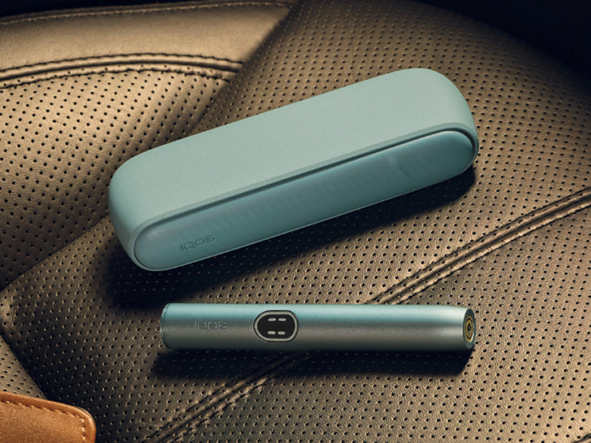 A Breeze Blue IQOS ILUMA i device on a seat.