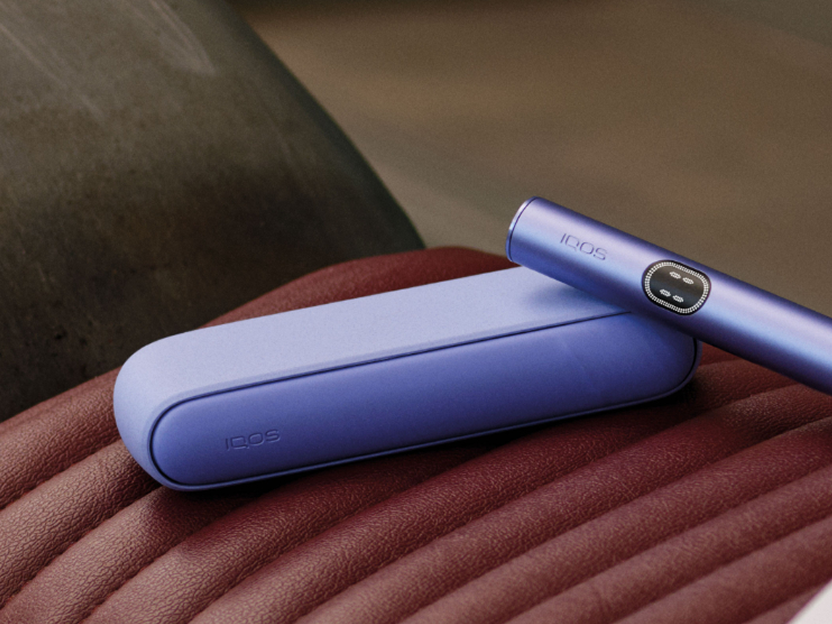 A Digital Violet IQOS ILUMA i device on a seat.