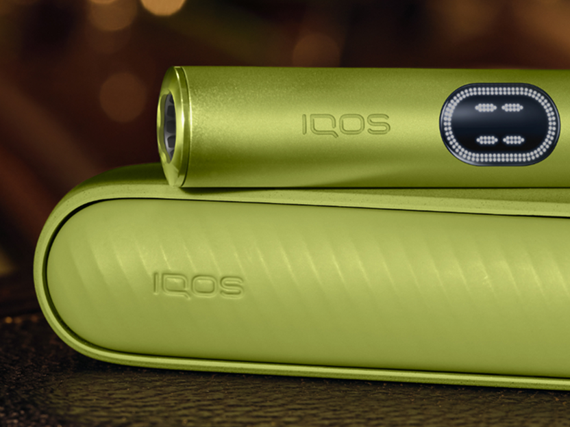 A close-up shot of a Leaf Green IQOS ILUMA i device.