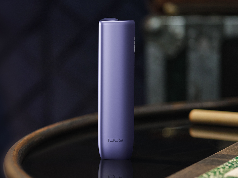 Un appareil IQOS  ILUMA i ONE Violet Digital posé sur un plateau.