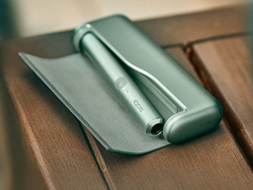 Un appareil vert jade IQOS ILUMA PRIME dans un étui ouvert.