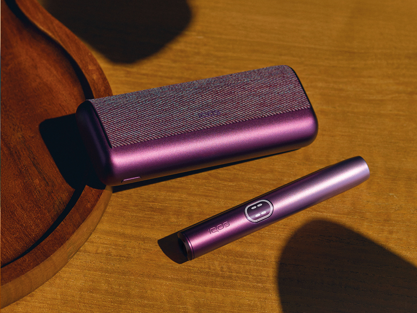 A Midnight Black IQOS ILUMA i PRIME device on table.