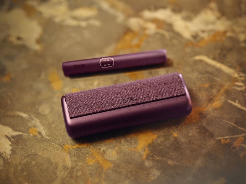 A Midnight Black IQOS ILUMA i PRIME device on table.
