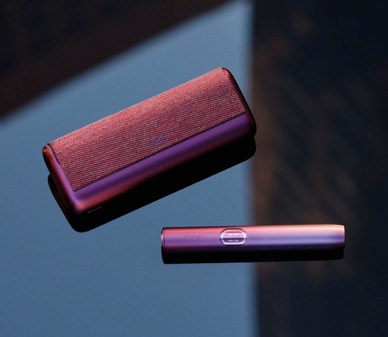 Un appareil IQOS ILUMA PRIME avec un bâtonnet TEREA à l’intérieur sur une table en bois. 