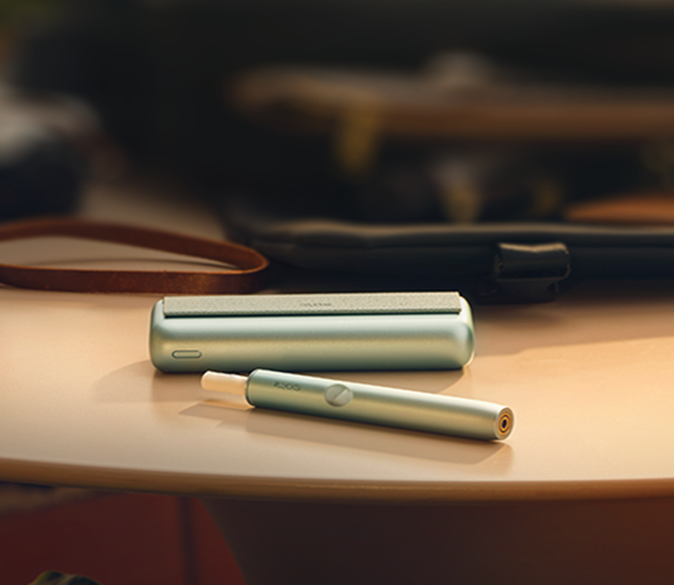 Un appareil IQOS ILUMA PRIME avec un bâtonnet TEREA à l’intérieur sur une table en bois.