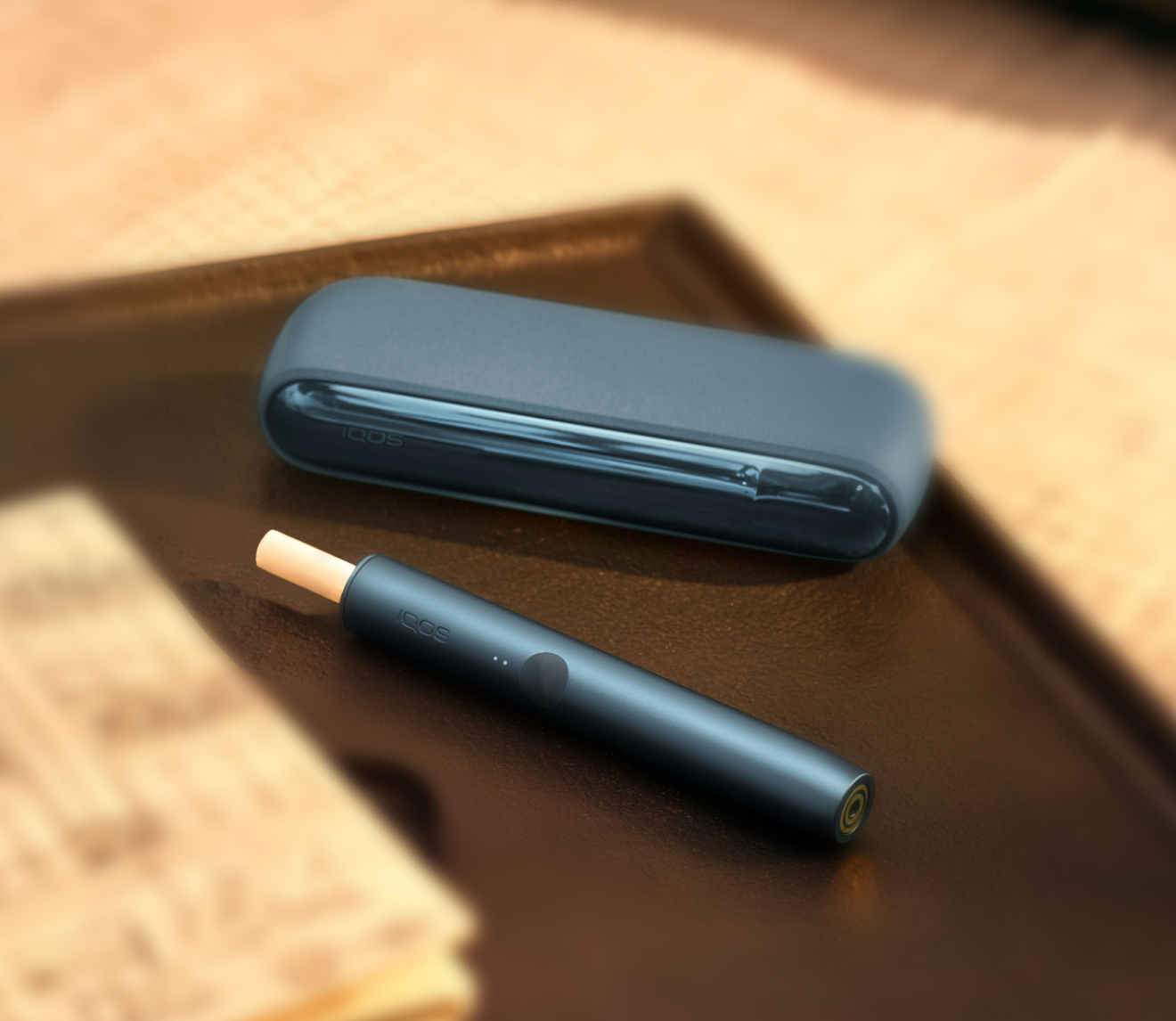 Un appareil IQOS ILUMA avec un bâtonnet TEREA à l’intérieur sur un plateau.