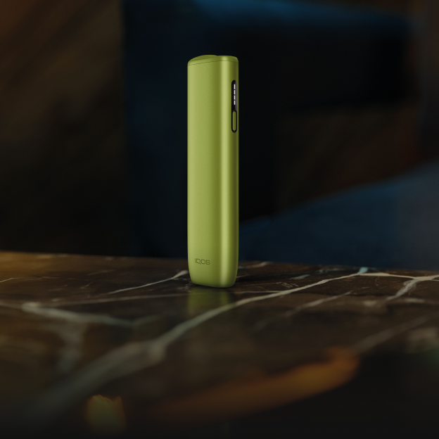 Un appareil IQOS ILUMA i ONE Vert Feuille sur une table.