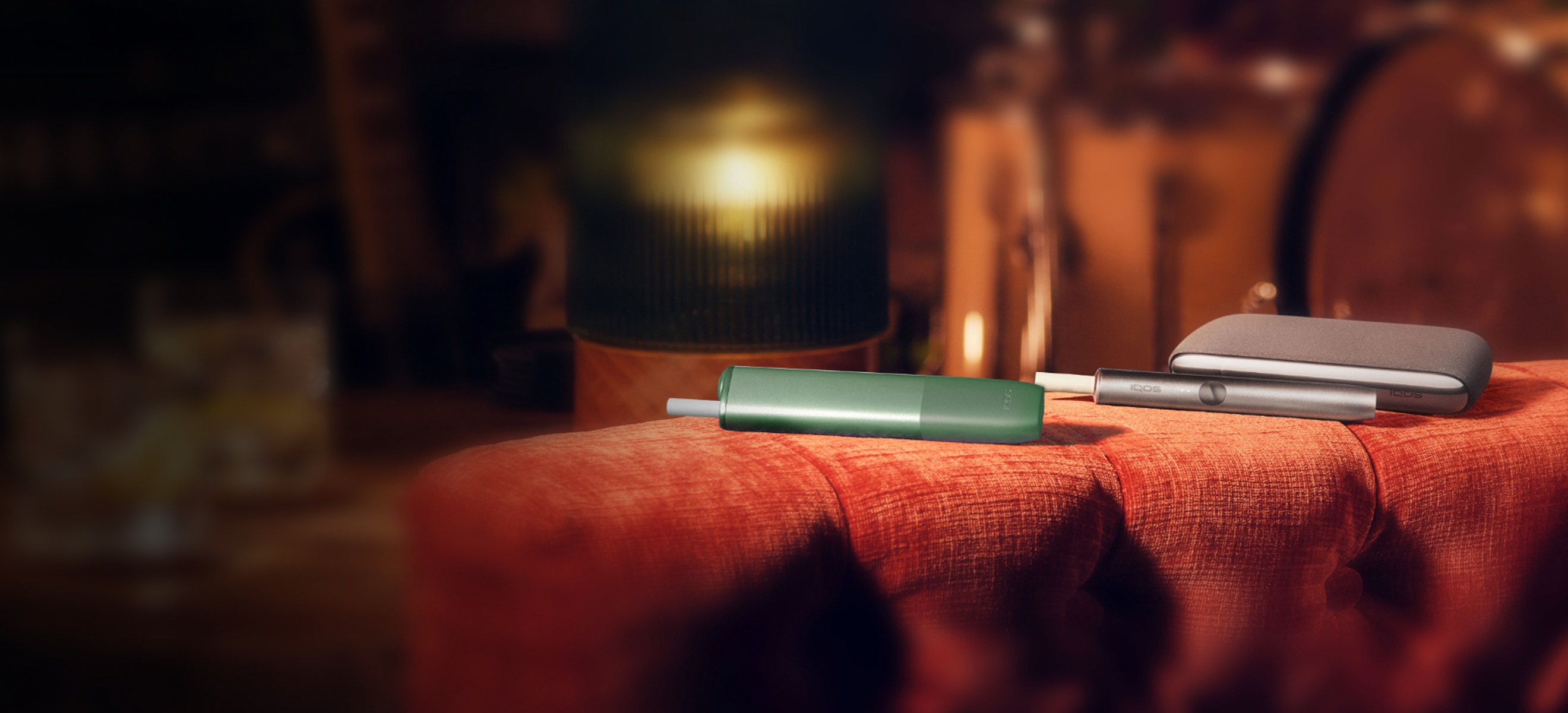 Un appareil IQOS ILUMA et IQOS ILUMA ONE avec des bâtonnets TEREA à l’intérieur sur une table.