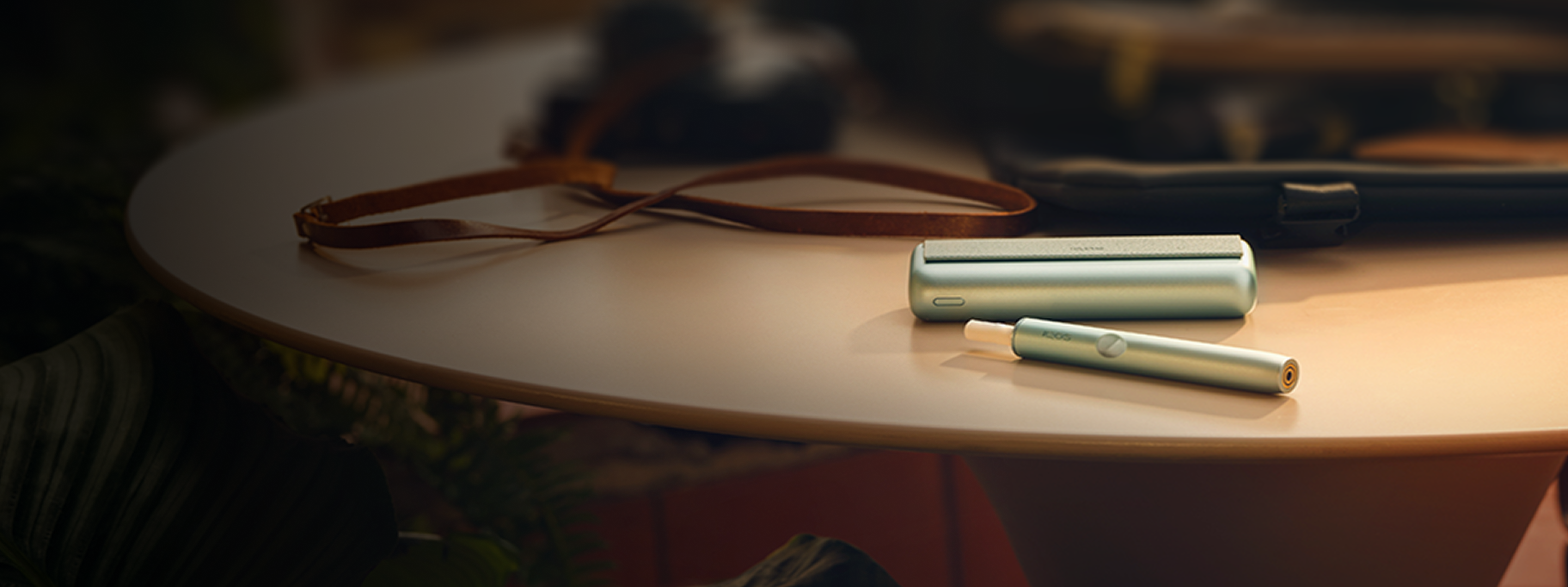 Un appareil IQOS ILUMA PRIME avec un bâtonnet TEREA à l’intérieur sur une table. 