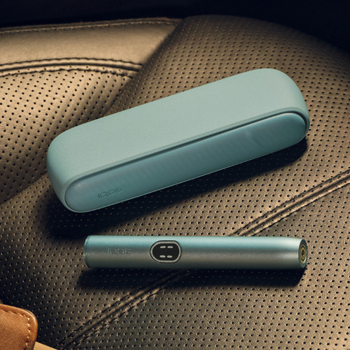 A Breeze Blue IQOS ILUMA i device on a seat.