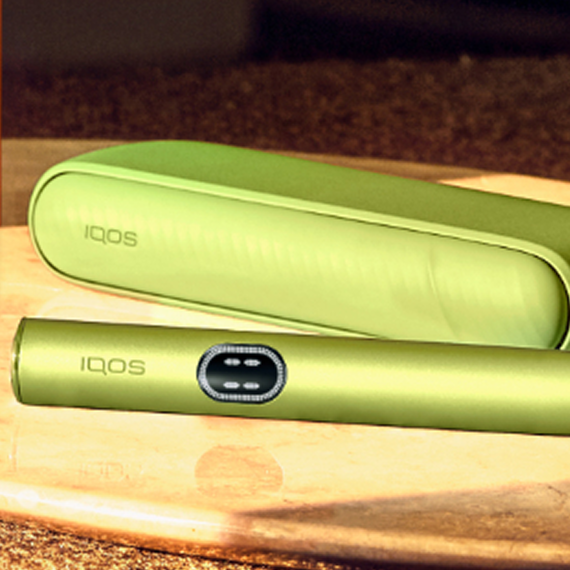 A Leaf Green IQOS ILUMA i device on a tray.
