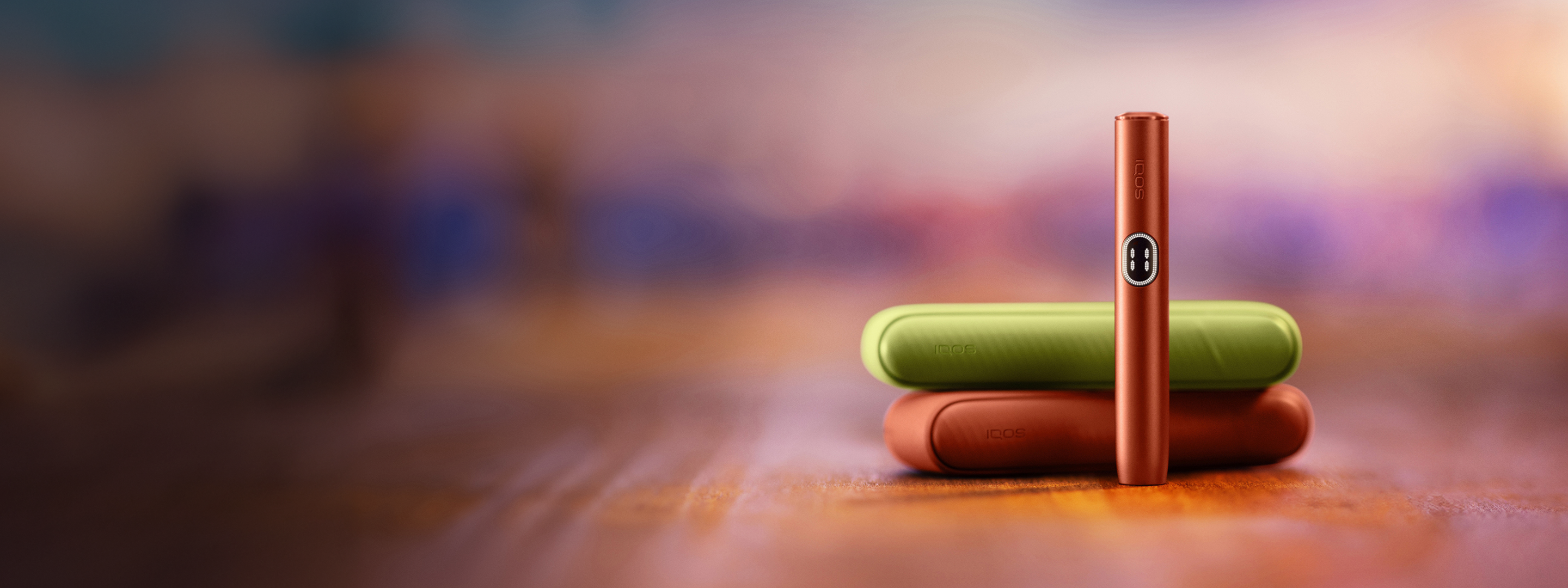 Vivid Terracota and Aspen Green IQOS ILUMA i devices on the floor.