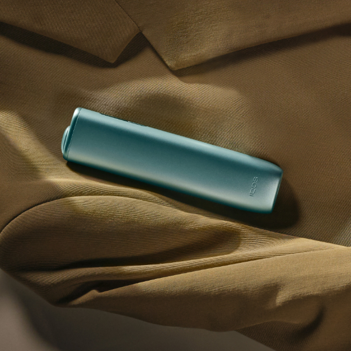 A Breeze Blue IQOS ILUMA i ONE device on a coat.