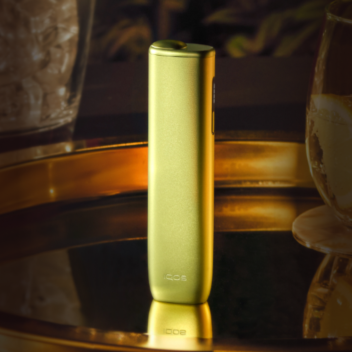 A Leaf Green IQOS ILUMA i ONE device standing up on a tray. 