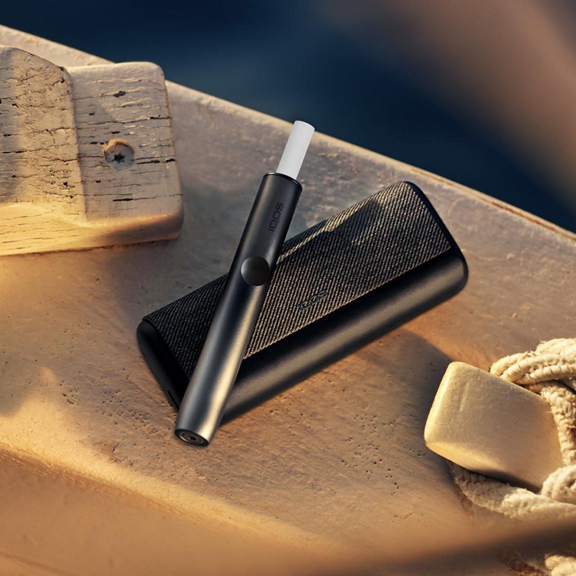 A Jade Green IQOS ILUMA PRIME Pocket Charger on a table.