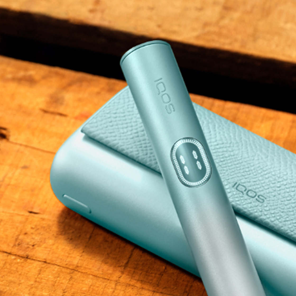 A Breeze Blue IQOS ILUMA i PRIME device on a wooden table.