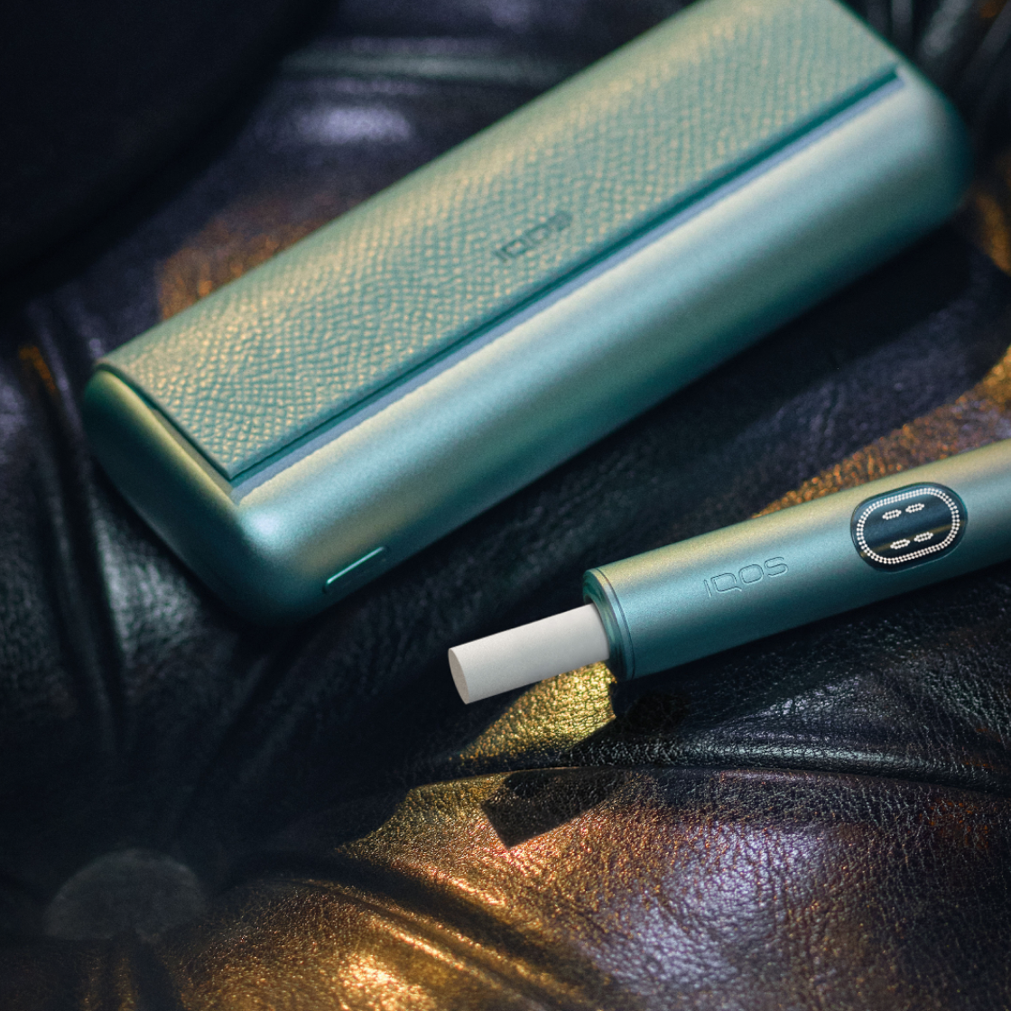 A Breeze Blue IQOS ILUMA i PRIME device on a seat.
