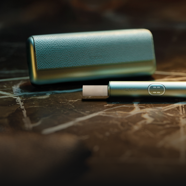 A Breeze Blue IQOS ILUMA i PRIME device with a TEREA stick inserted on a table.