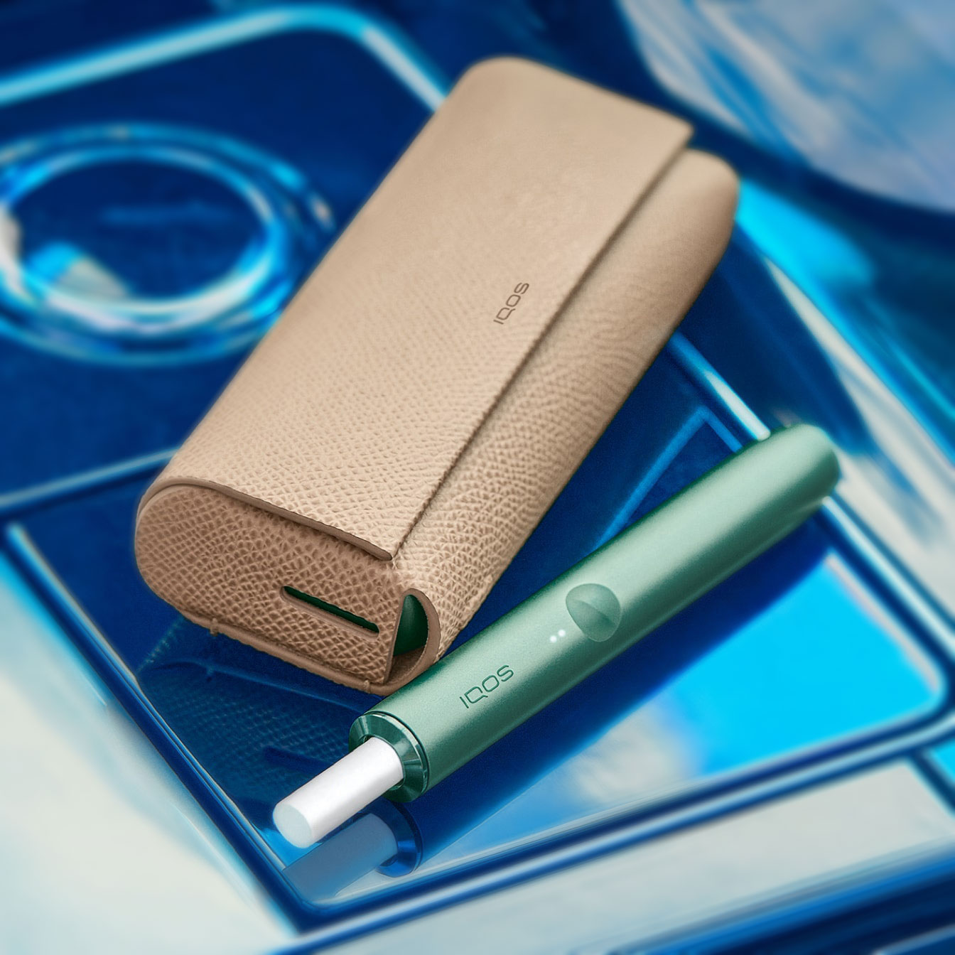 Un support IQOS ILUMA PRIME vert jade et un revêtement complet sur un chargeur de poche.