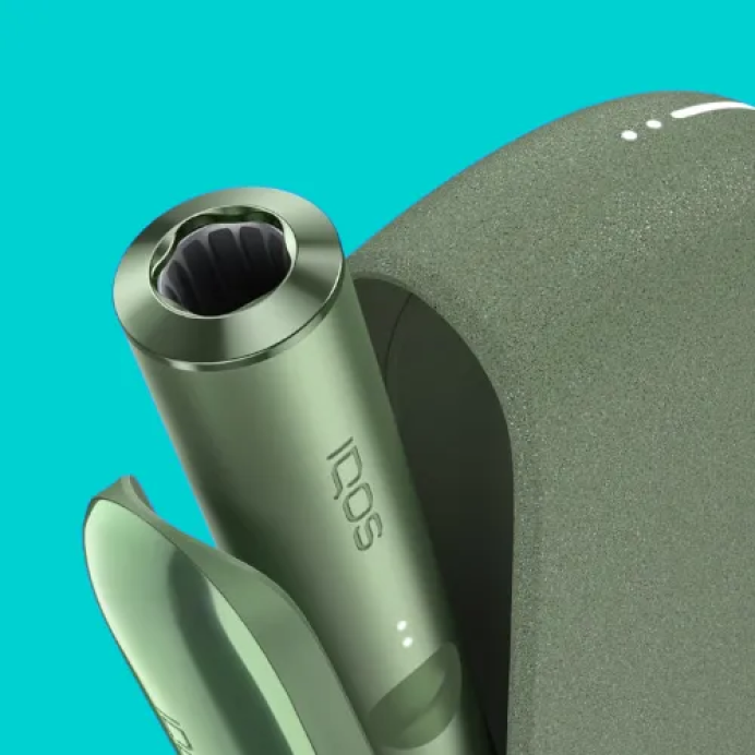 Un appareil IQOS ILUMA vert mousse et un chargeur de poche.