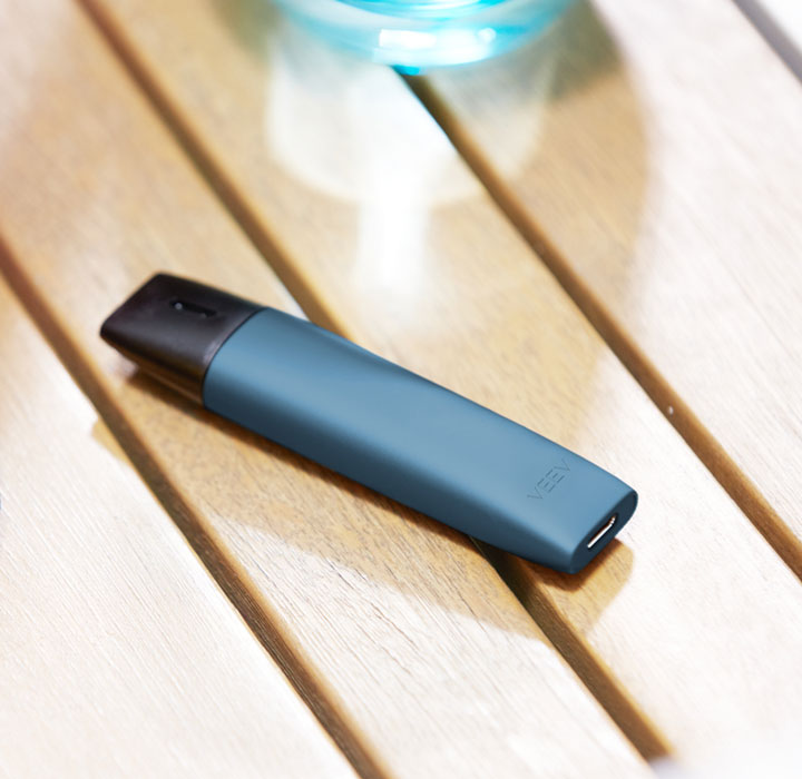 A blue VEEV device on the table.