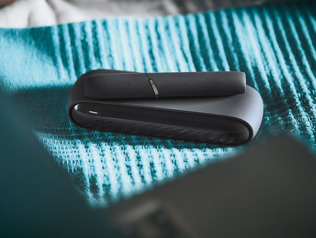 IQOS DUO gris sur couverture turquoise