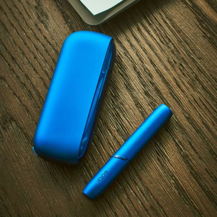 IQOS 3 DUO de couleur bleue sur une table en bois