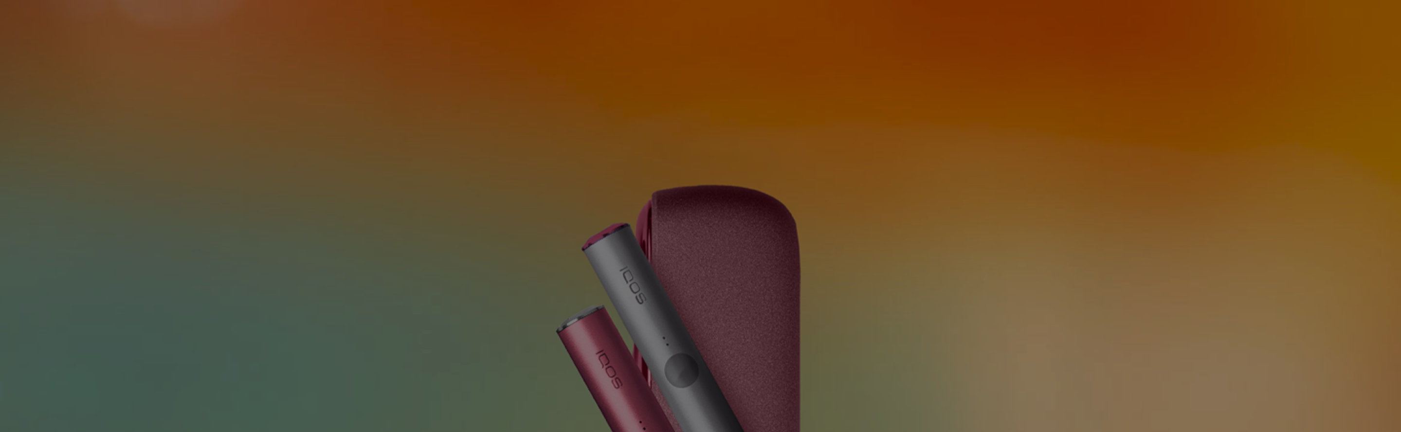 Sunset Red IQOS ILUMA device. Sunset Red IQOS ILUMA holder with Silvery Metal Ring. Pebble Grey IQOS ILUMA holder with Prisma Metal Ring.  