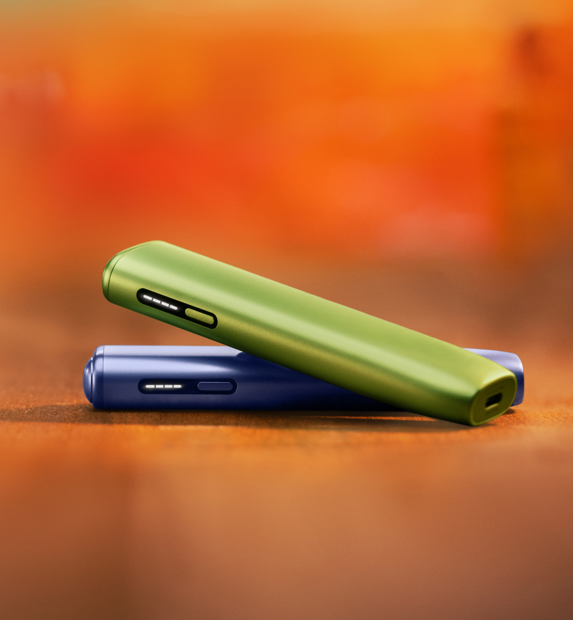 Un appareil IQOS ILUMA i ONE vert feuille et un appareil IQOS ILUMA i ONE violet numérique empilés l’un sur l’autre.
