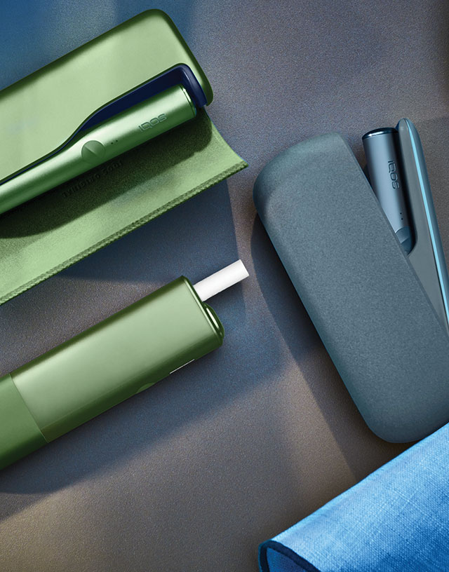 Moss Green IQOS ILUMA PRIME, Moss Green IQOS ILUMA ONE et Azure Blue IQOS ILUMA device sur une table