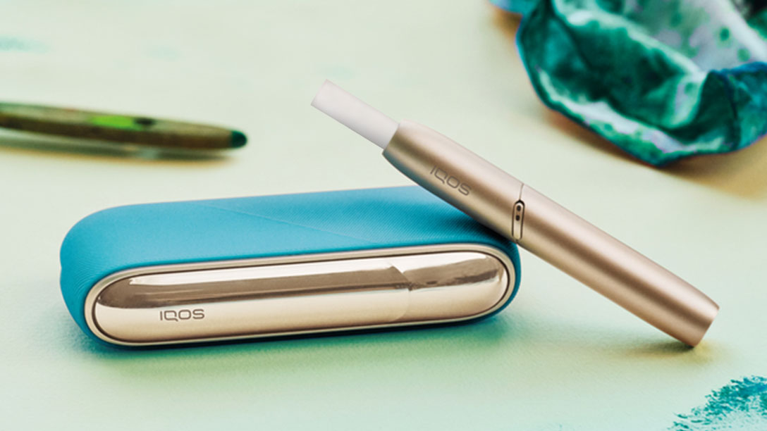 Un IQOS 3 DUO de couleur or avec un étui bleu
